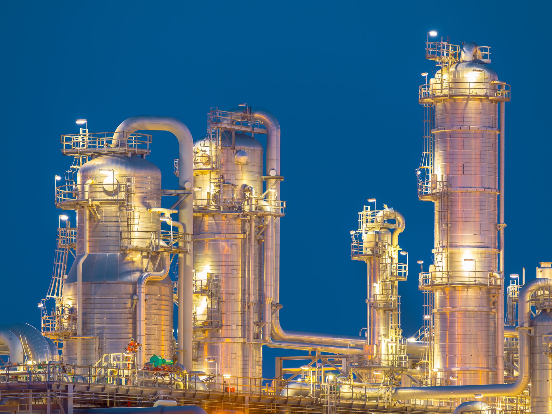 Chemical distillation and processing towers at a gas plant, representing the downstream operations a well forecast helps the firm plan around