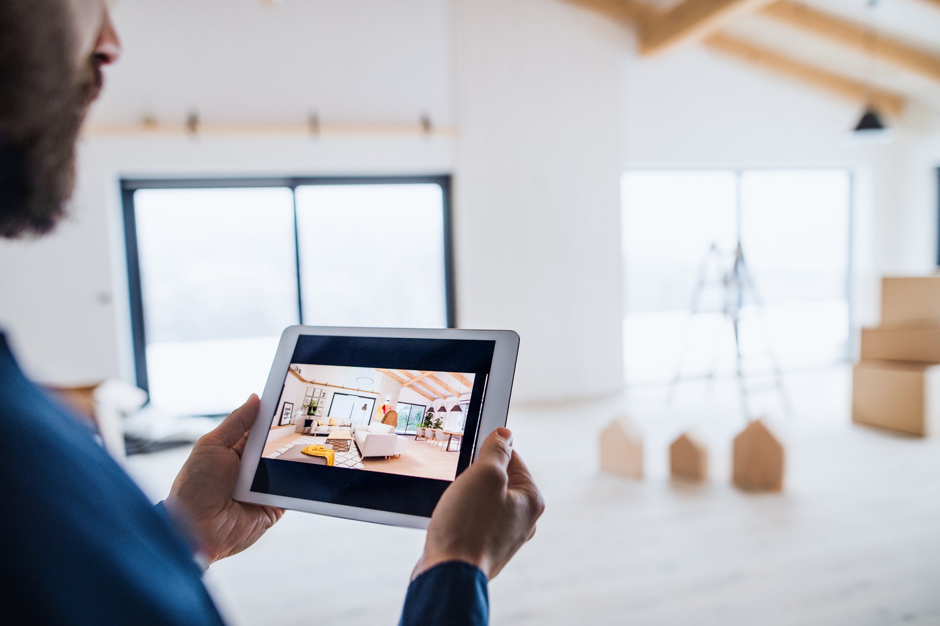A site supervisor holding a tablet on a construction site, reviewing an interior build against the current drawings stored in Microsoft 365