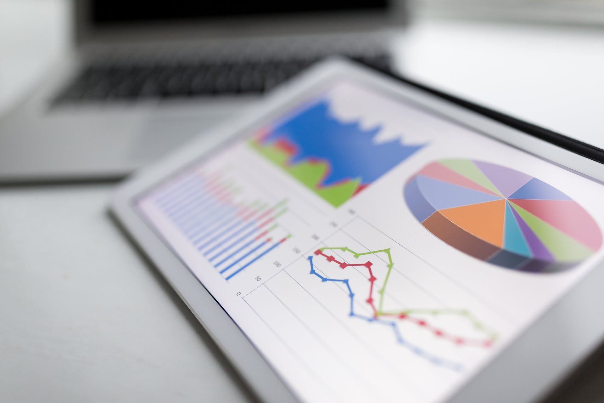 A tablet on a desk showing practice statistics and charts, the franchise view Power BI puts in front of head office
