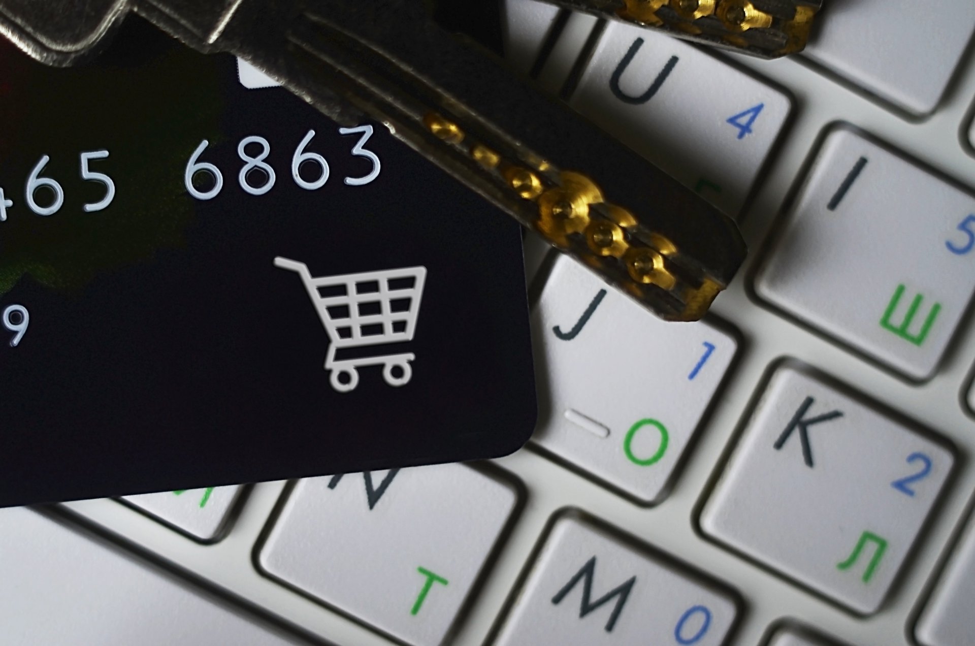Online shopping on a laptop with a credit card and house keys beside it, representing a customer paying at a checkout they already trust