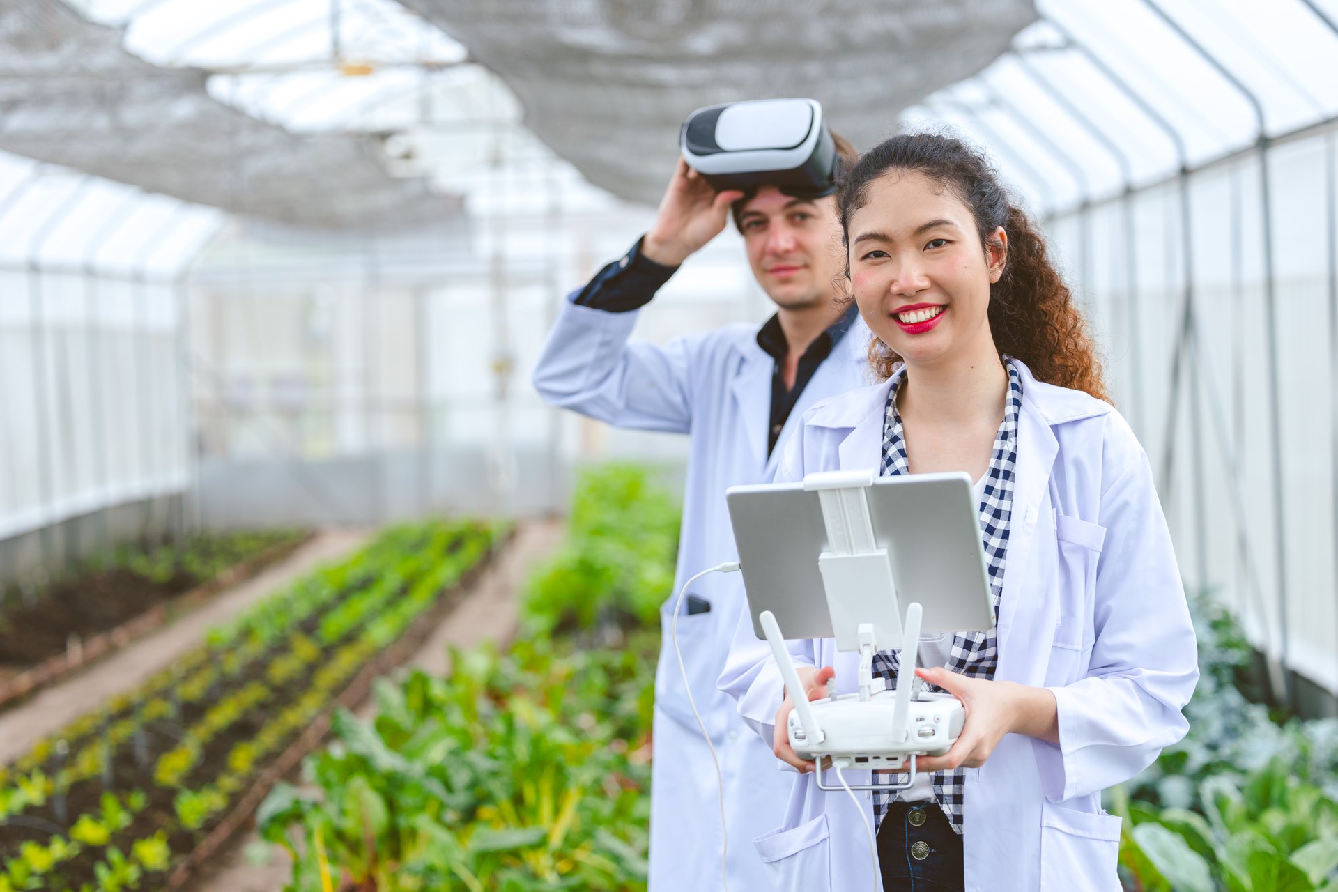 A precision-agriculture researcher flying a drone with a fly-view controller over a broadacre crop