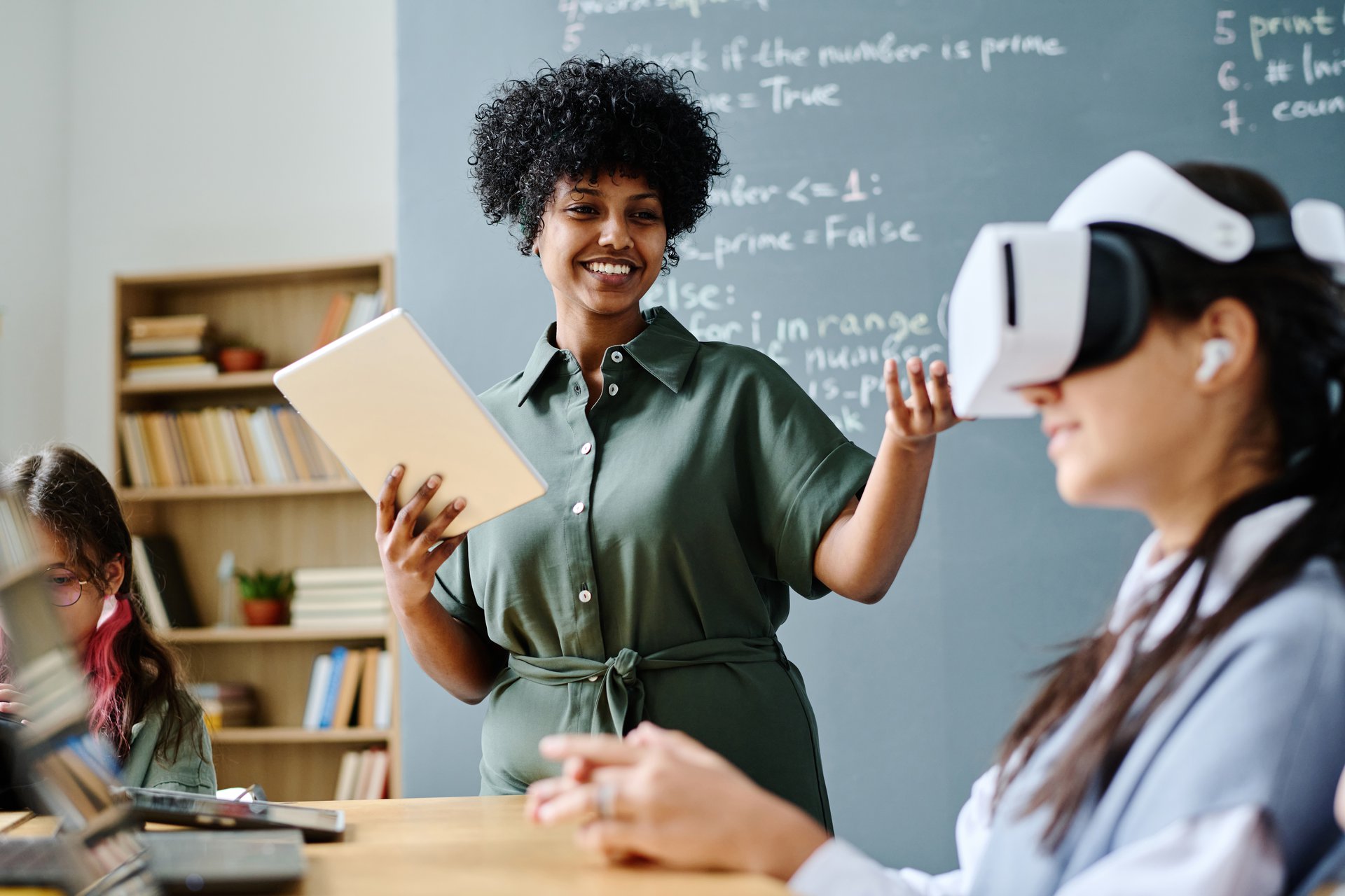 A teacher running an IT lesson with students at computers, the classroom learning an adaptive product aims to support
