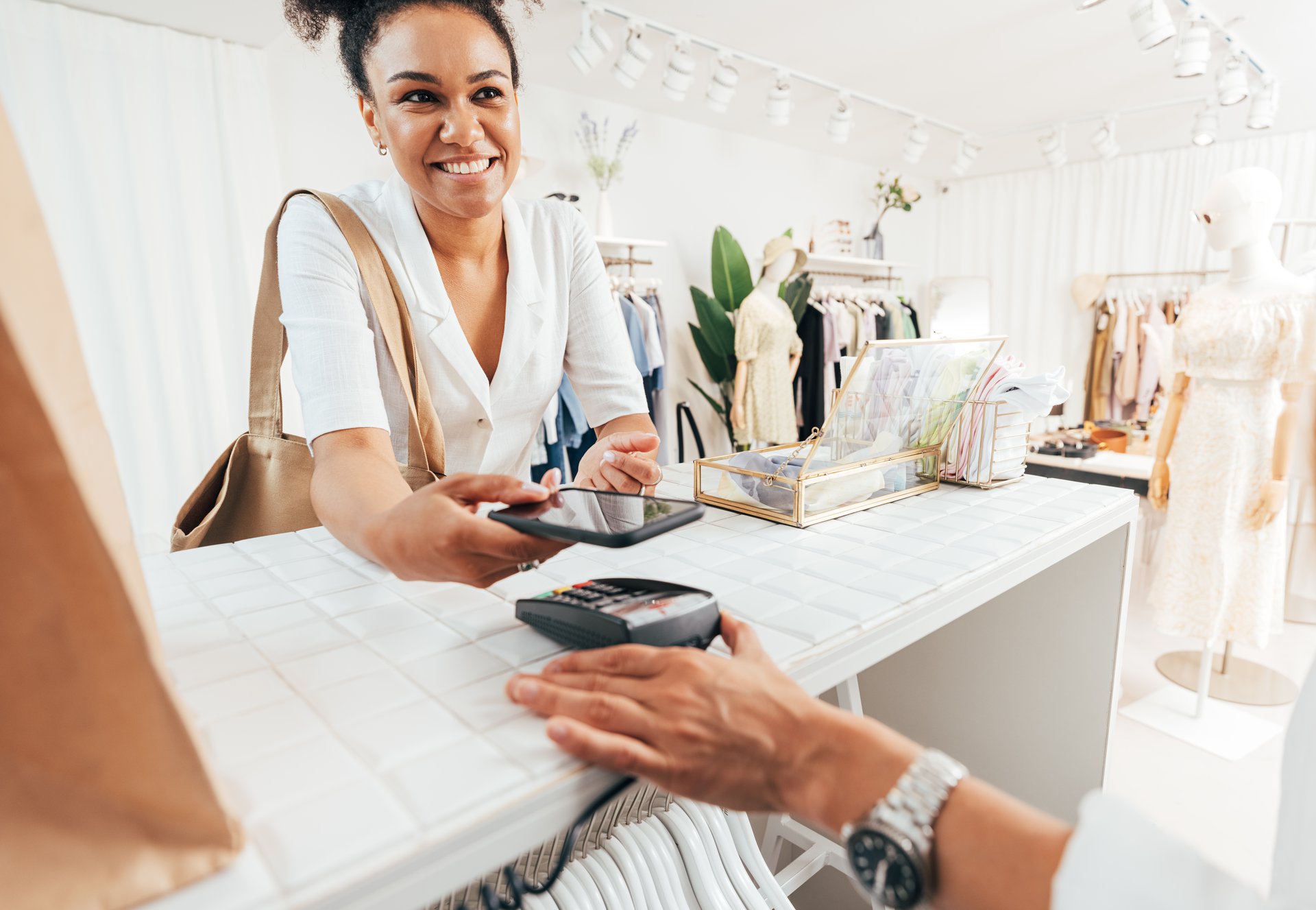 A customer paying with a smartphone at a shop counter, representing the everyday retail moments behind each support question.